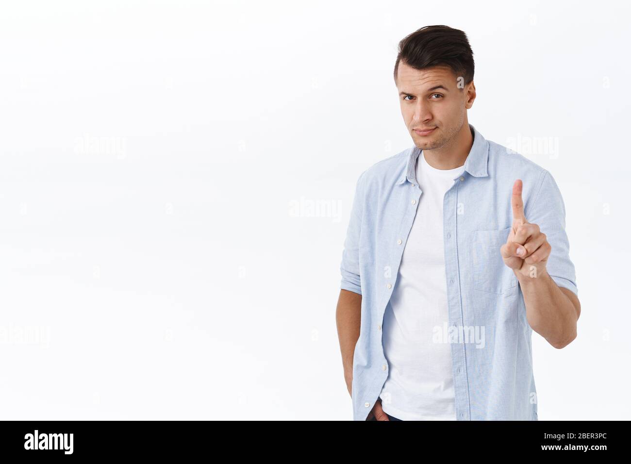 Not so fast. Portrait of stylish macho man, handsome guy shaking index finger in prohibition, forbid action, smiling confident, disagree or scold Stock Photo