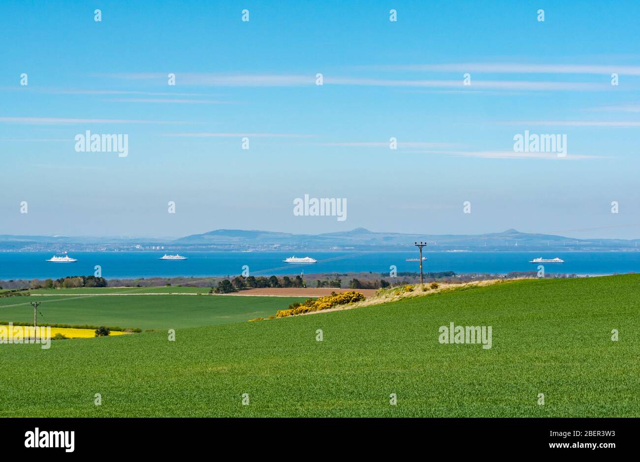 East Lothian, Scotland, United Kingdom. 15th April 2020. UK Weather: In the distance, the mothballed Fred Olsen cruise ships are anchored in the Firth of Forth out of service due to the Covid-19 pandemic. L to R: MV Boudicca, MV Black Watch, MV Balmoral, MV Braemar Stock Photo