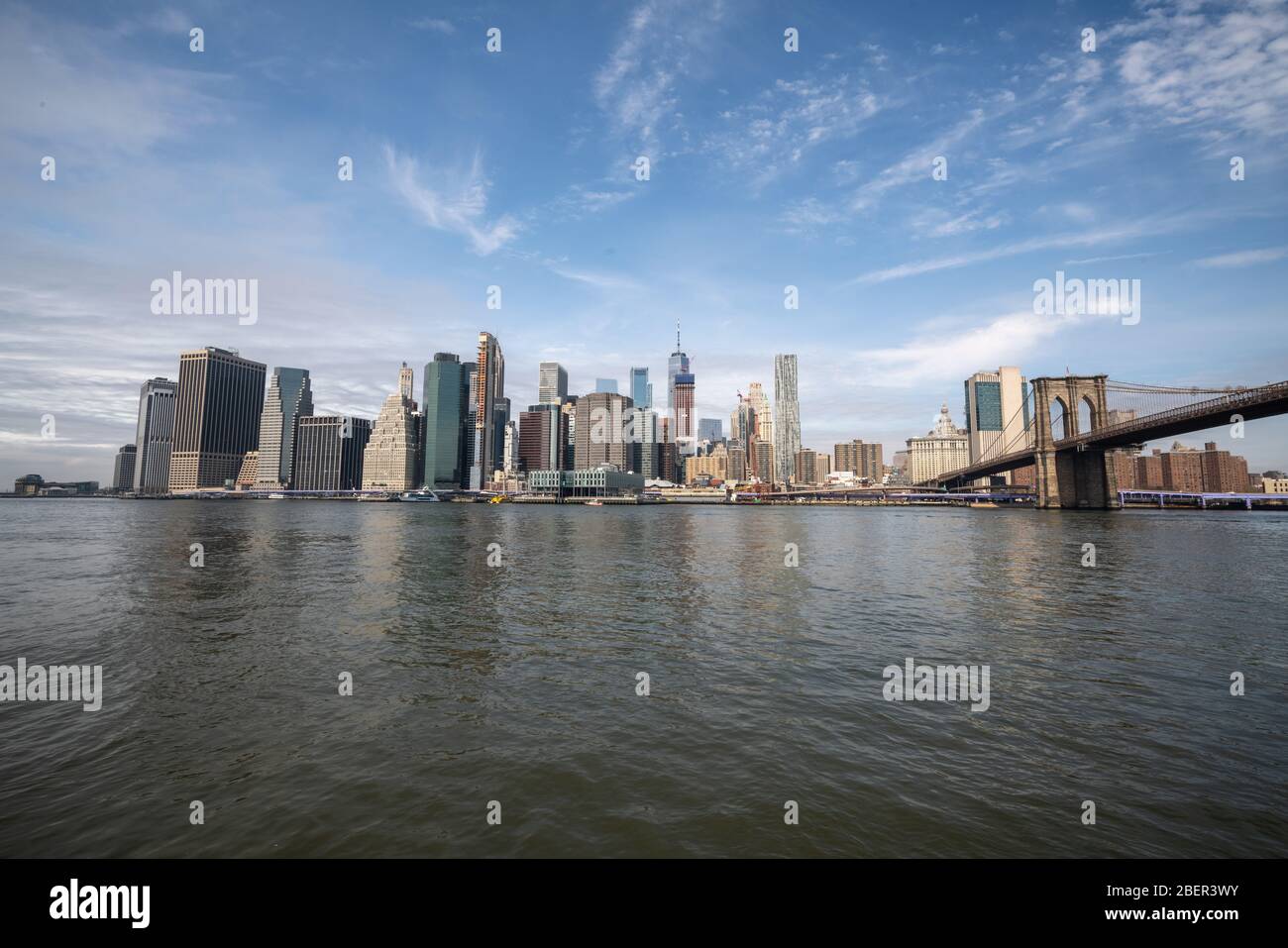 New york skyline reflection on the Hudson river at Brooklyn bridge at ...