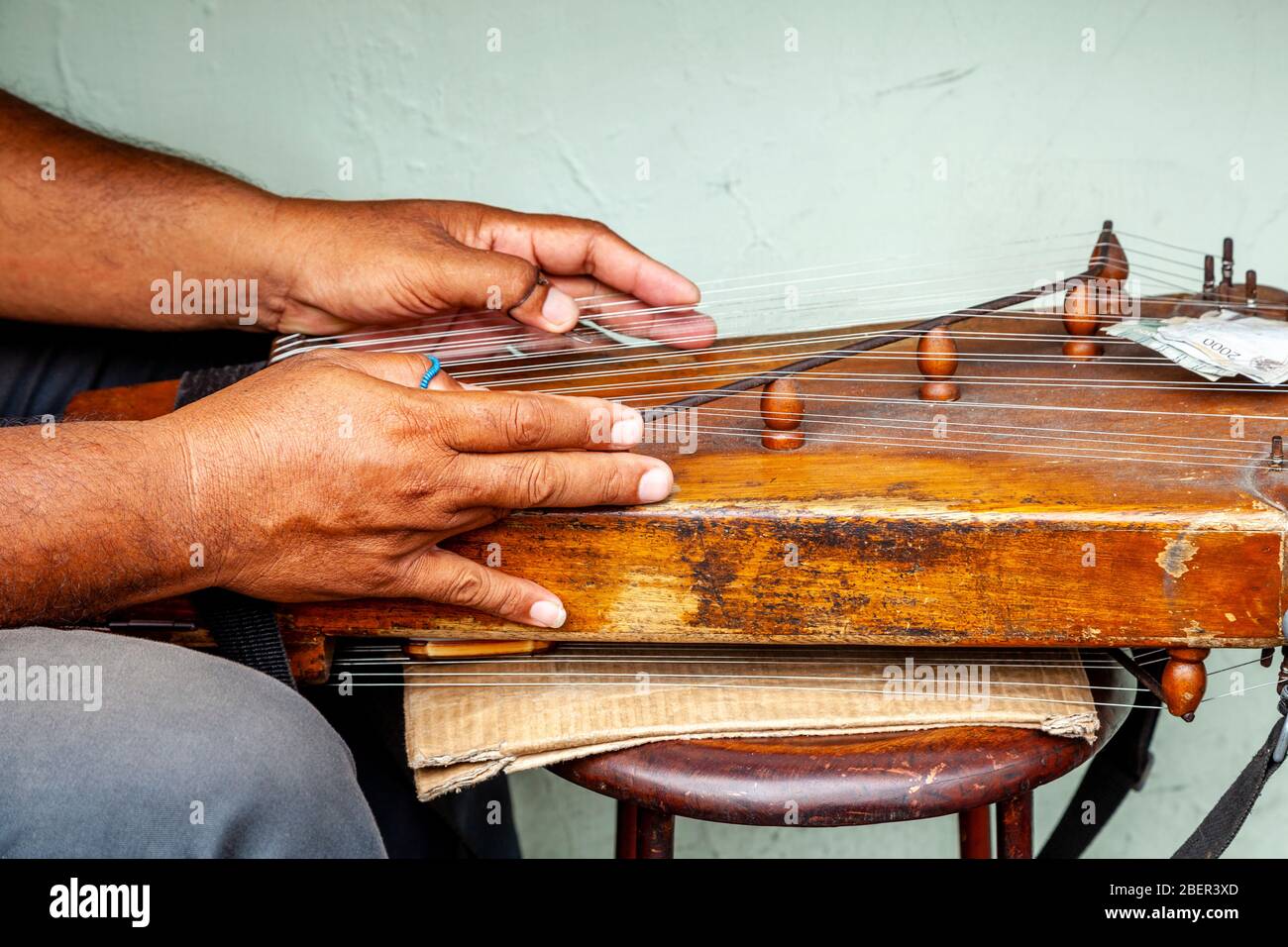 An Indonesian Man Plucking At A Stringed Instrument, Yogyakarta, Java, Indonesia. Stock Photo