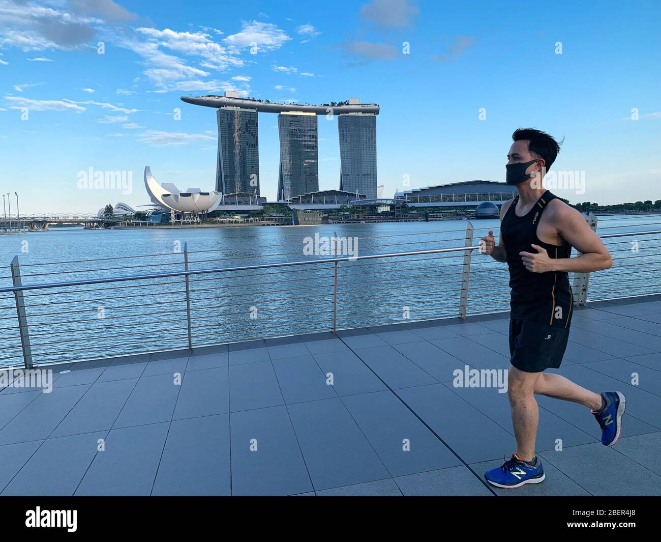 Singapore. 15th Apr 2020. A runner wears a face-mask jogging in Marina Bay in Singapore on 15 April 2020. As of April 14th it is now mandatory to wear a face mask when outside the house except during strenuous exercise or for babies under two years old. First time offenders will be fined SGD300 and repeat offenders are liable for higher fines or prosecution. The new regulation was introduced to help combat the COVID-19 novel coronavirus. Credit: Haruhiko Otsuka/AFLO/Alamy Live News Stock Photo