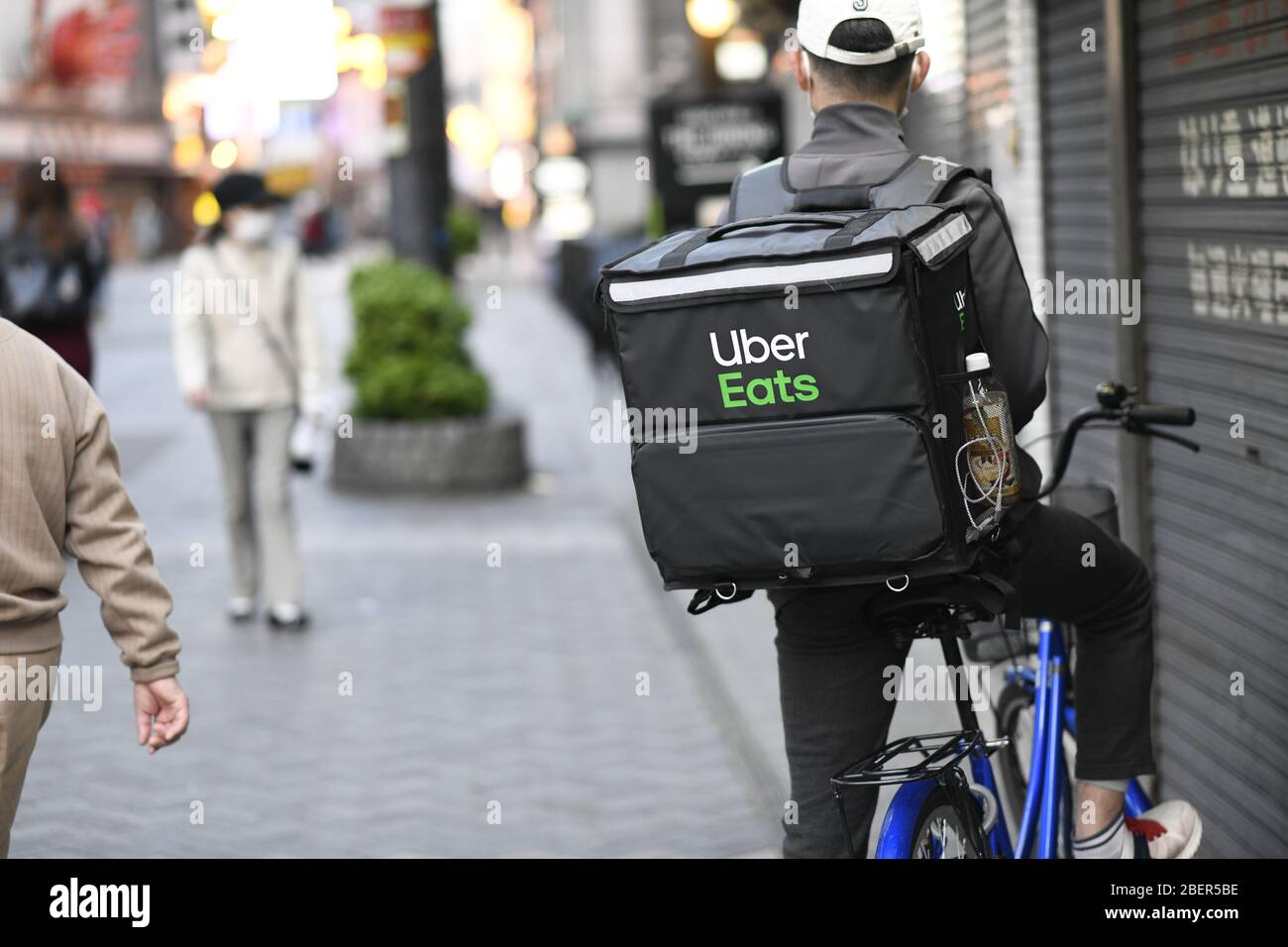OSAKA, JAPAN - APRIL 15: An Uber Eats delivery man rides a bicycle 