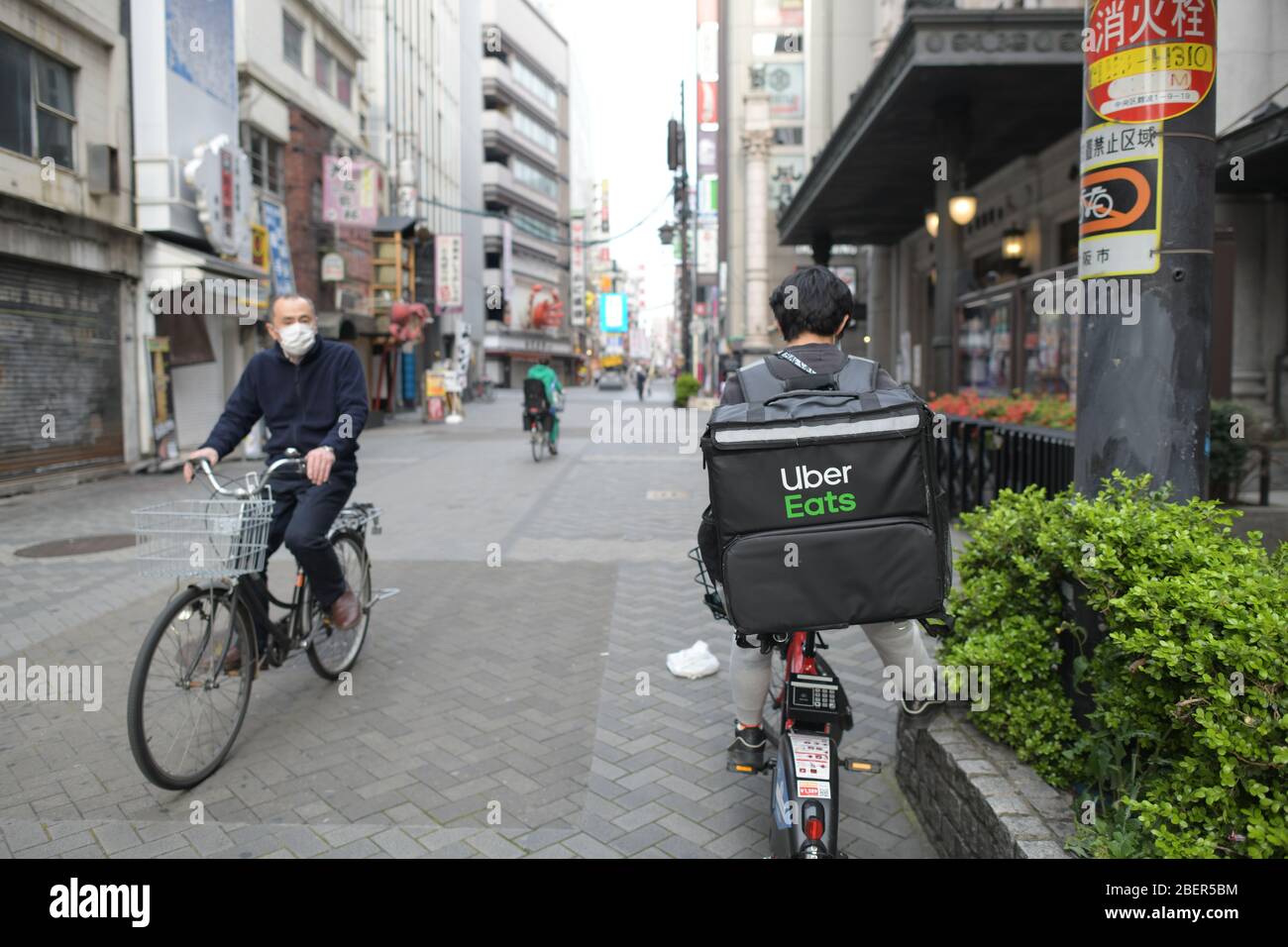 OSAKA, JAPAN - APRIL 15: An Uber Eats delivery man checks his 