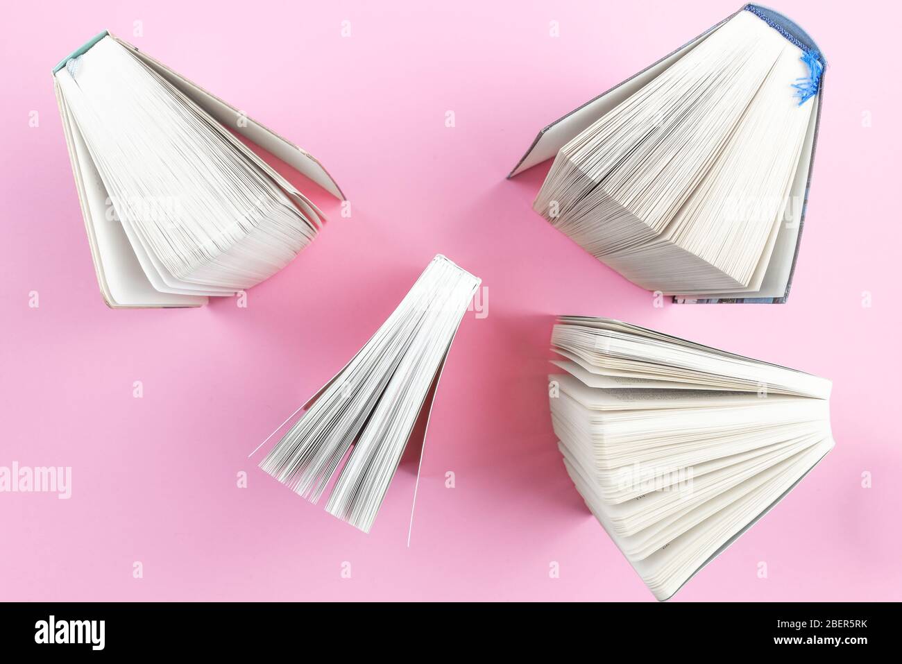 top view of fanned out books on pink desk Stock Photo