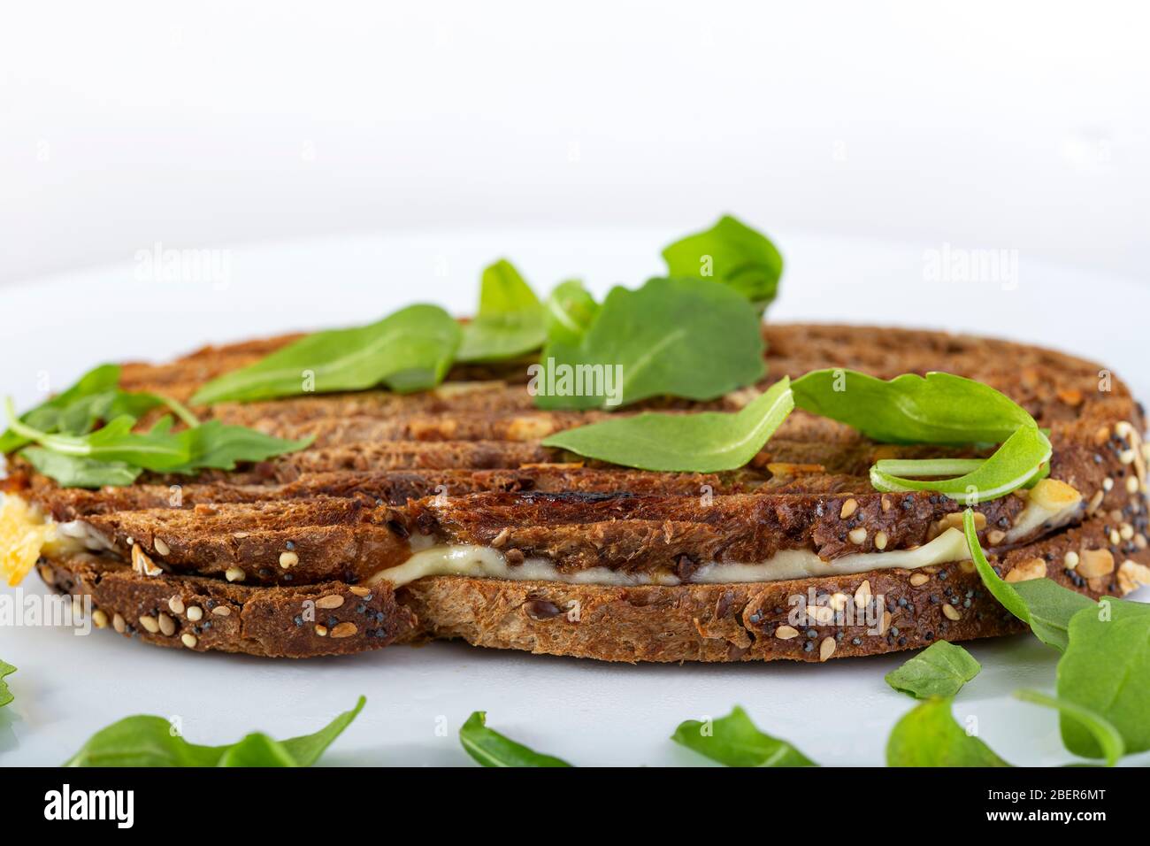 Toasted sandwich with cheese, ham and green arugula Stock Photo