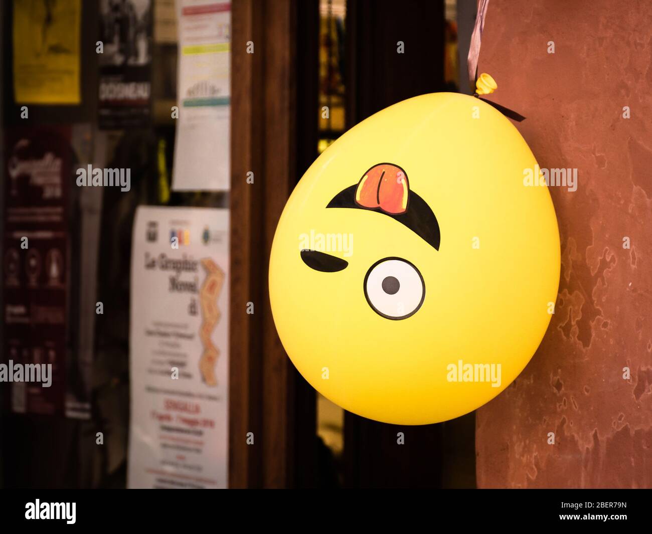 Winking emoji balloon hangs upside down outside a shop in Senigallia, Le Marche, Italy Stock Photo