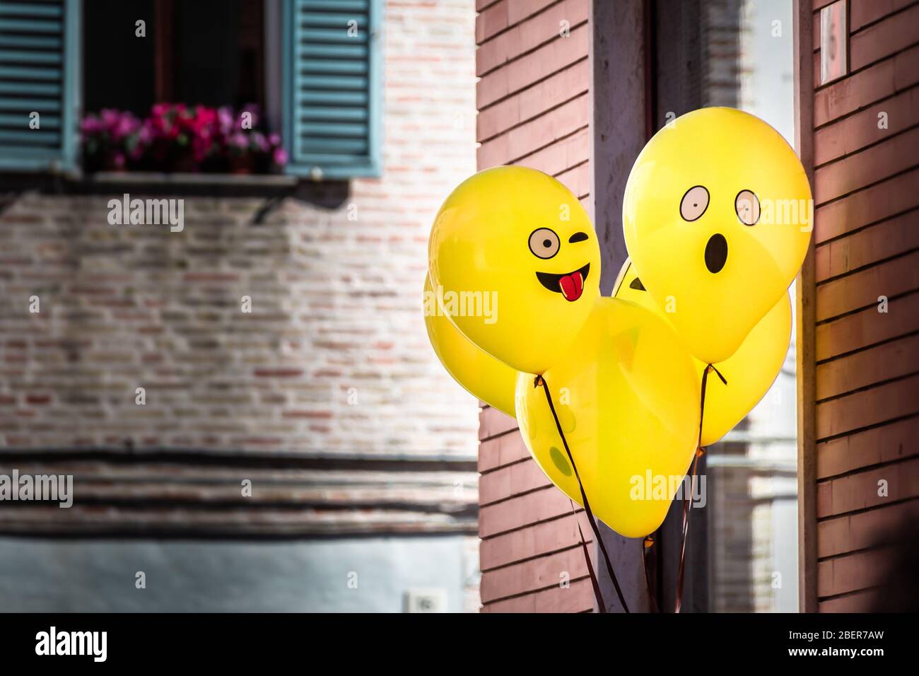 Yellow Emoji balloons floating at a street party in Senigallia, Le Marche, Italy Stock Photo