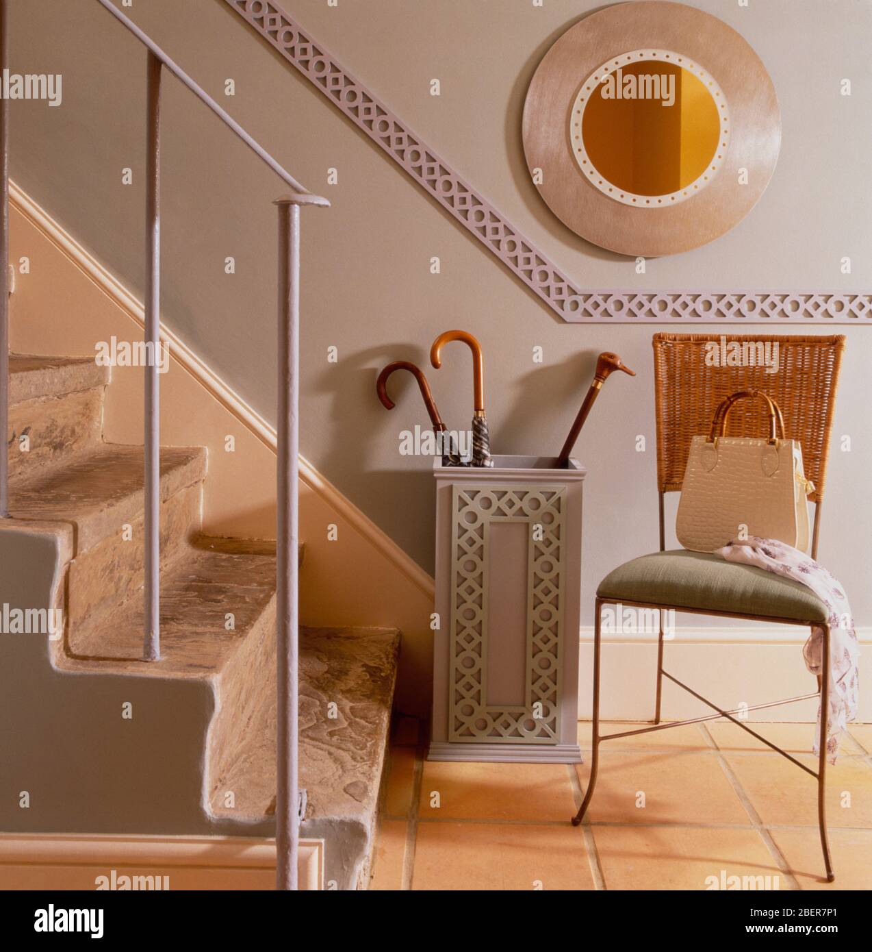 Hallway with umbrella stand and decorated dado going upstairs Stock Photo