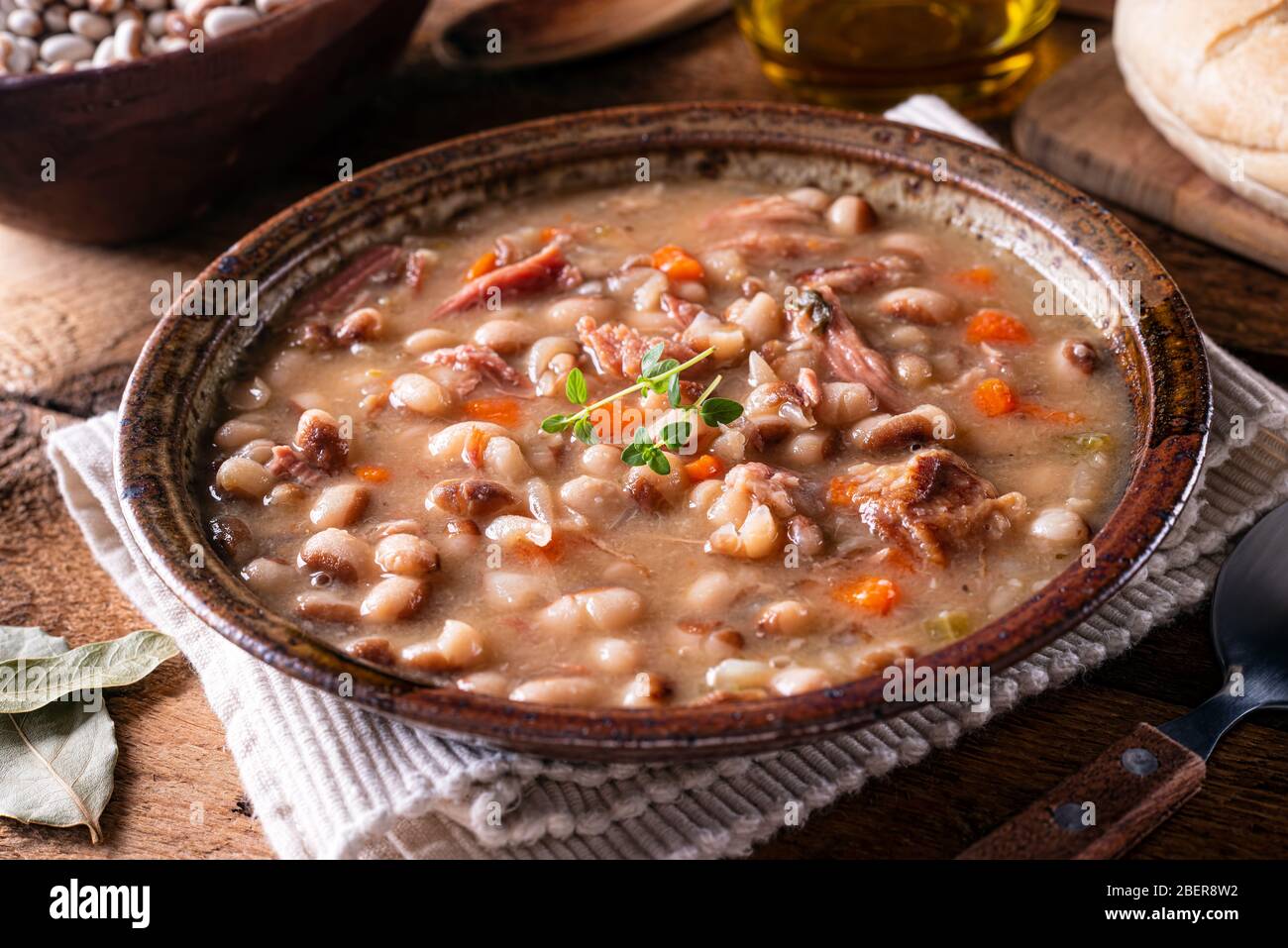 A bowl of delicious homemade bean soup with smoked ham and carrots. Stock Photo