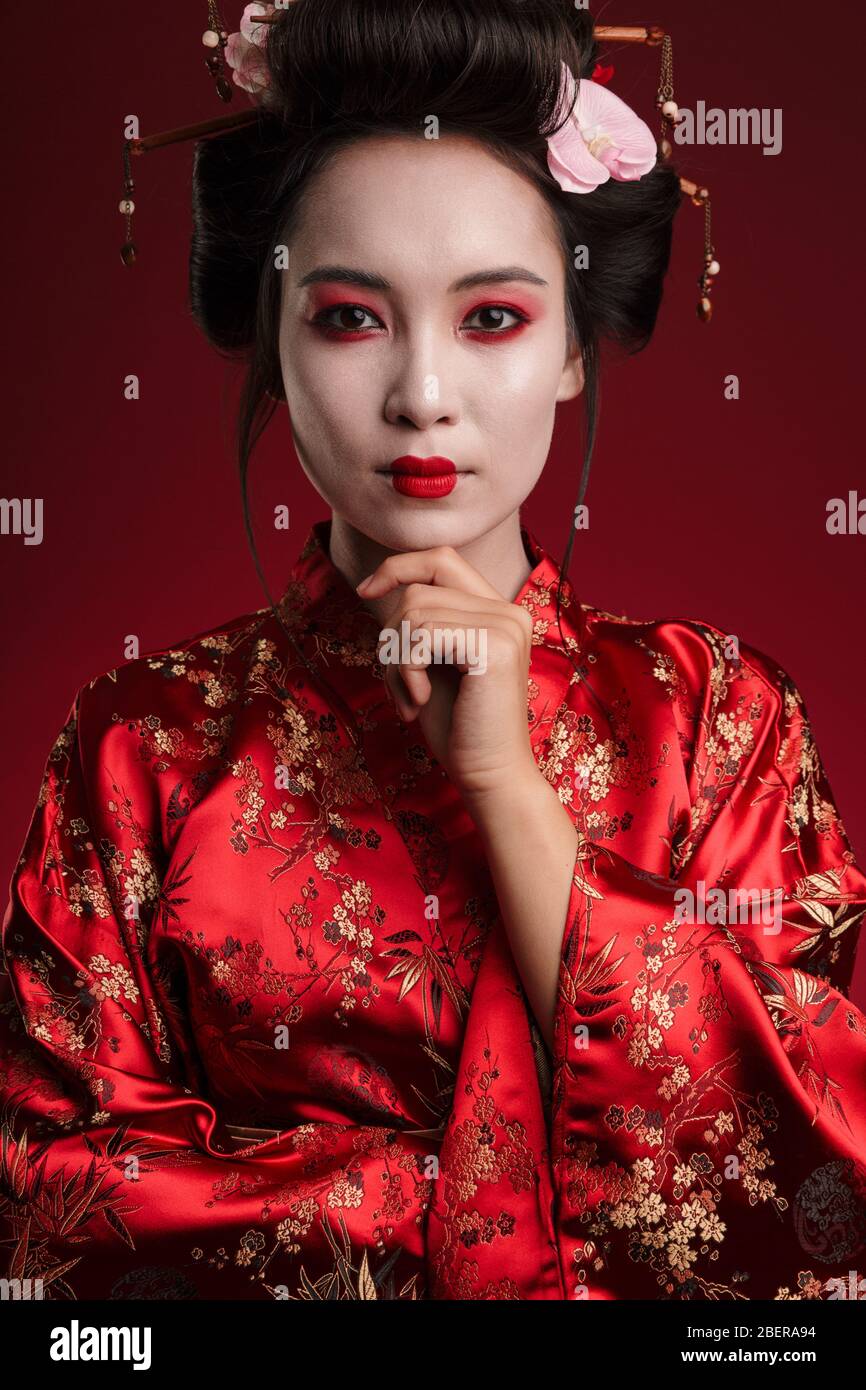 Image of attractive asian geisha woman in traditional japanese kimono  touching her chin isolated over red background Stock Photo - Alamy