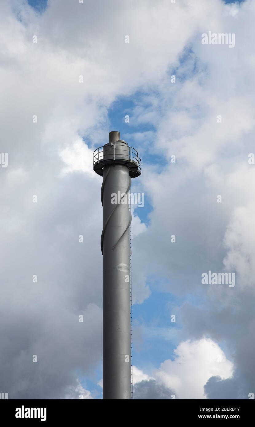 Helical strakes or corkscrew fin  at the top of a district heating power plant steel smokestack prevent vortex shedding , Finland Stock Photo