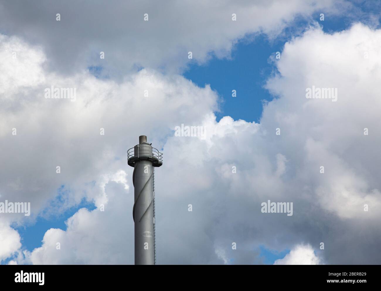 Helical strakes or corkscrew fin  at the top of a district heating power plant steel smokestack prevent vortex shedding , Finland Stock Photo