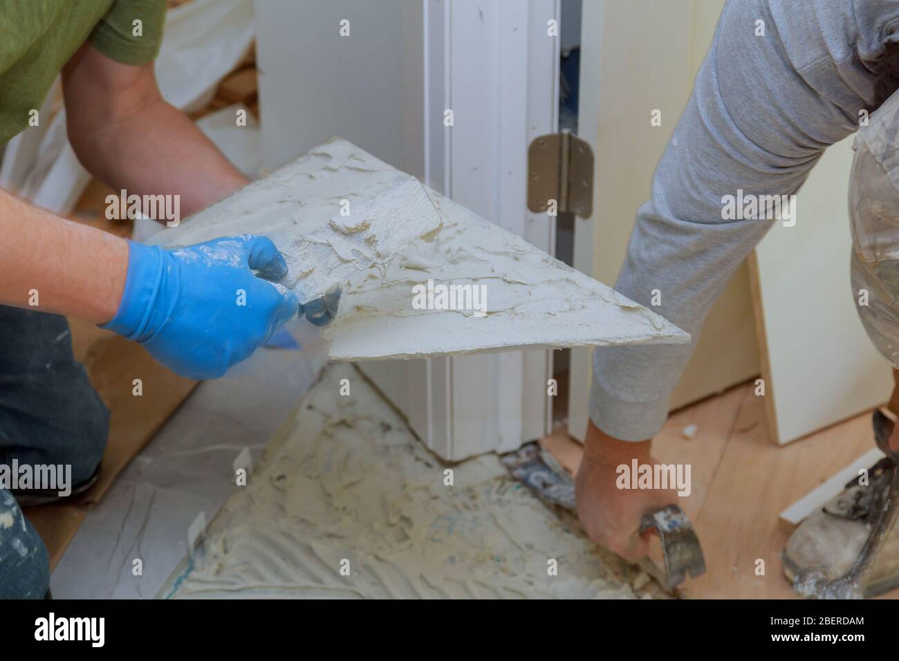 Spreading wet mortar before applying tiles on floor tile. Stock Photo