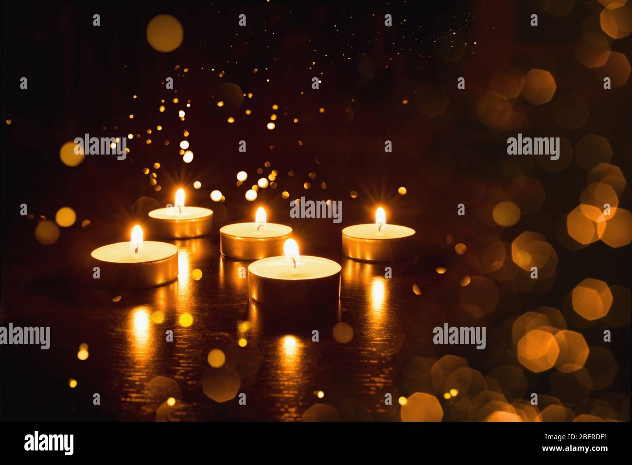 Several burning candles on a black background Stock Photo - Alamy