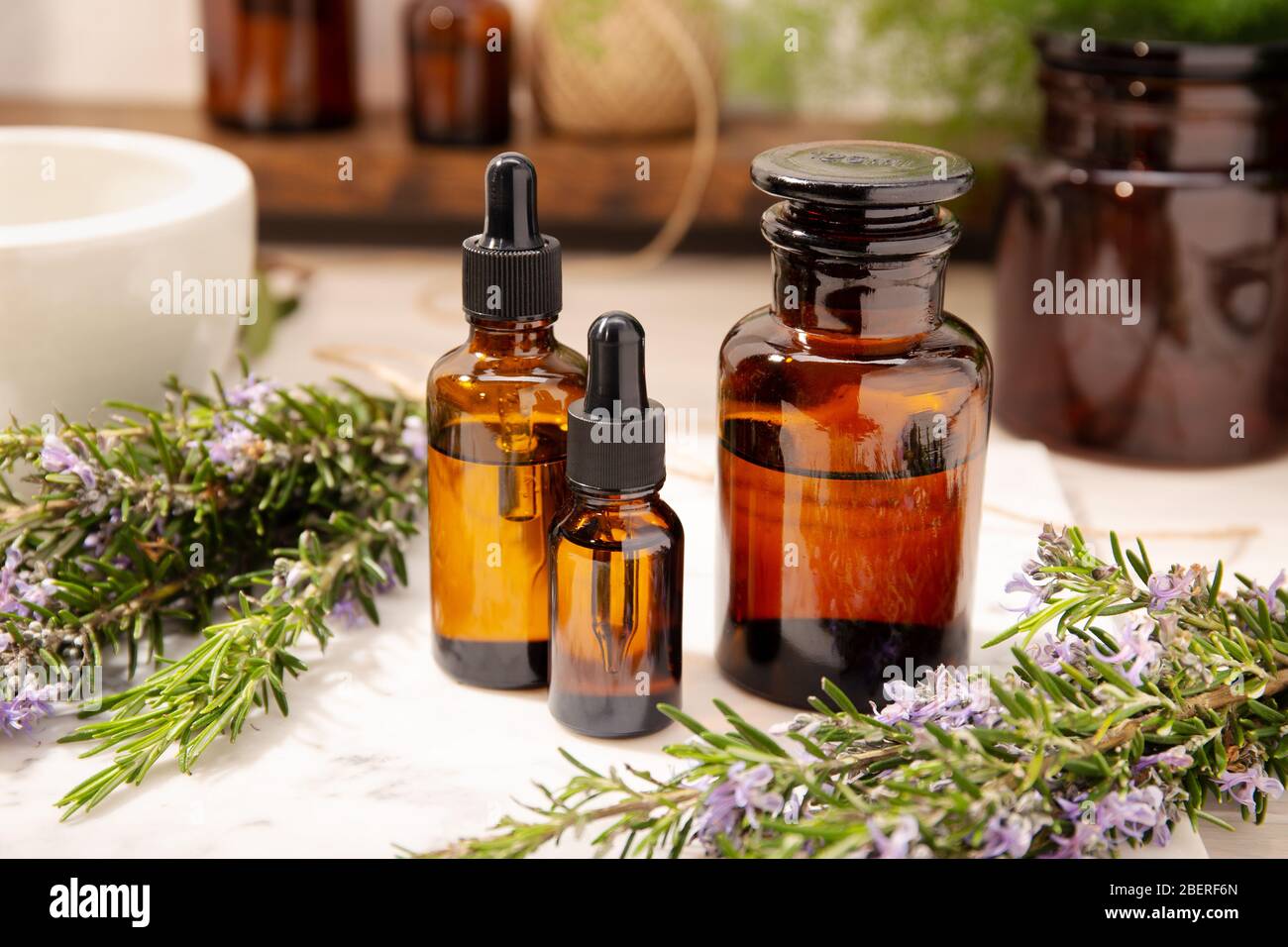 Rosemary essential oil on vintage apothecary bottles. Herbal oil for skin care, aromatherapy and natural medicine Stock Photo
