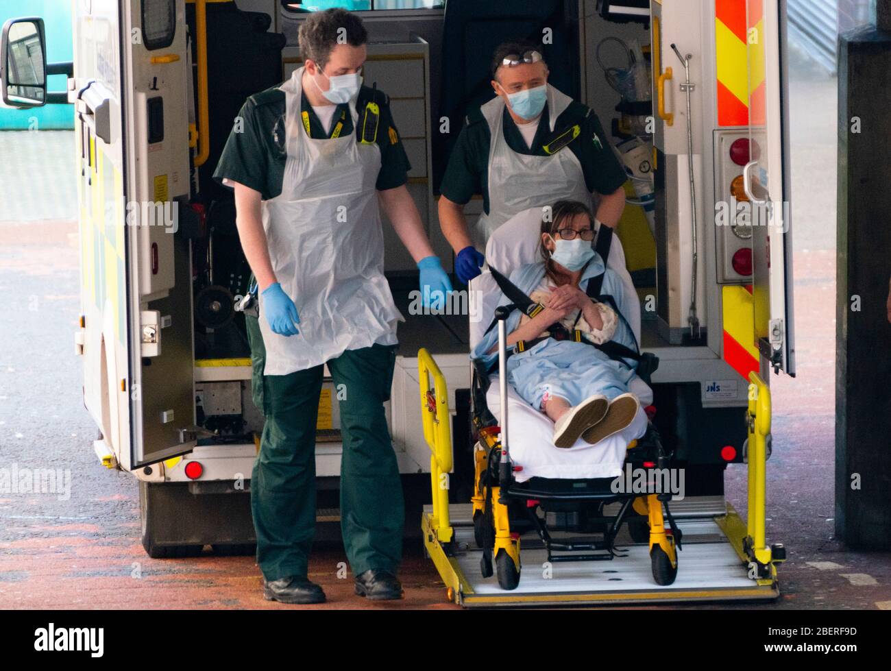 Glasgow, Scotland, UK. 15 April 2020. Patient is unloaded from ambulance by staff wearing PPE at A&E department at Glasgow Royal Infirmary. Iain Masterton/Alamy Live News Stock Photo