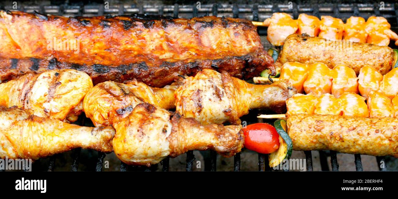 Various pieces of grilled meat on a grill grateVerschiedene Stücke Grillfleisch auf einem Grillrost Stock Photo