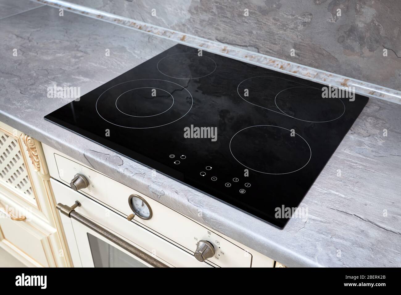 Modern kitchen interior with black induction or electric hob stove cooker  with ceramic top surface with marble countertop and wall decorated with  ston Stock Photo - Alamy