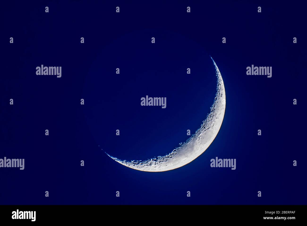 4-day old waxing crescent moon in blue twilight. Stock Photo