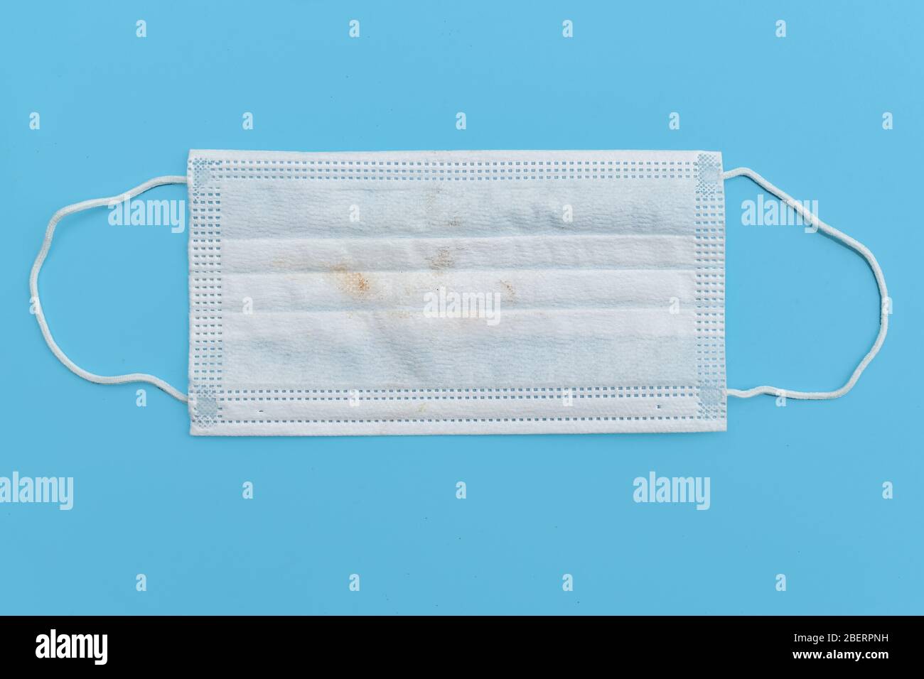 Used Medical face mask Dirty and contaminated after use more on blue background. Disposable surgical face mask cover the mouth and nose. protect Stock Photo