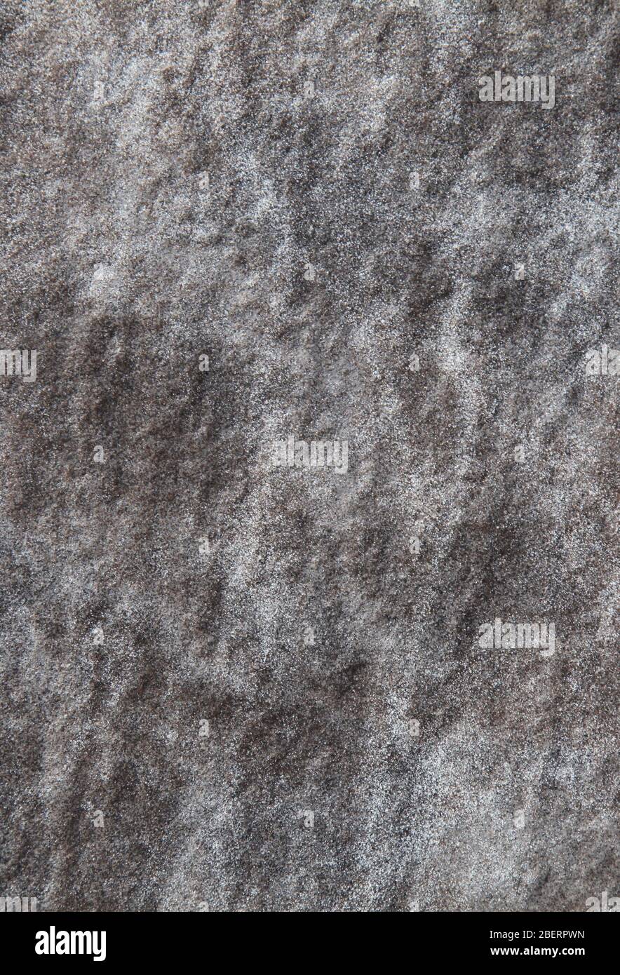 Wall surface made of volcanic stone, background. Dark rough wall texture with natural abstract pattern in white. Modern fashionable design Stock Photo