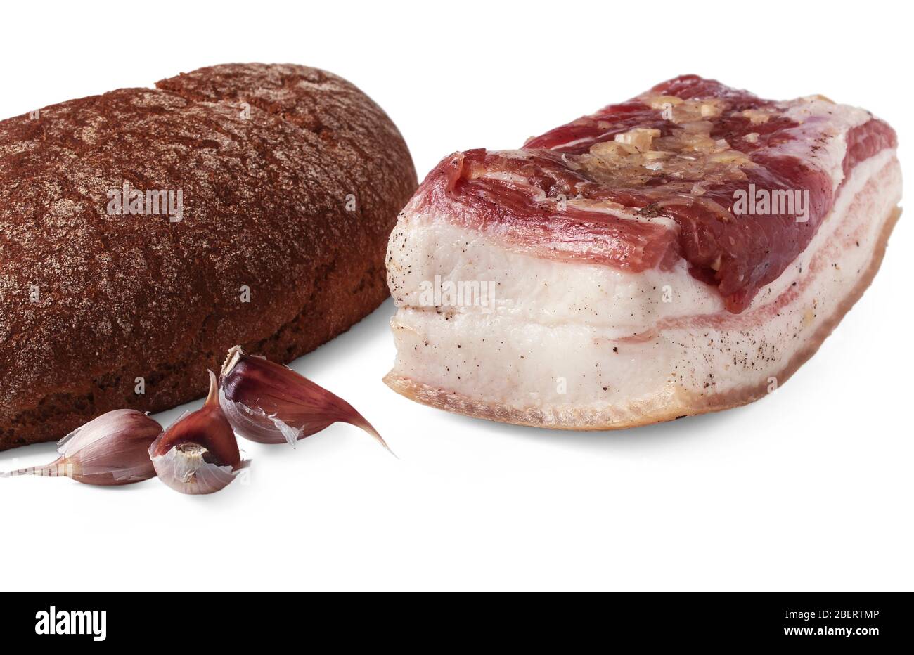 Salted lard, loaf of brown bread and cloves of garlic isolated on white