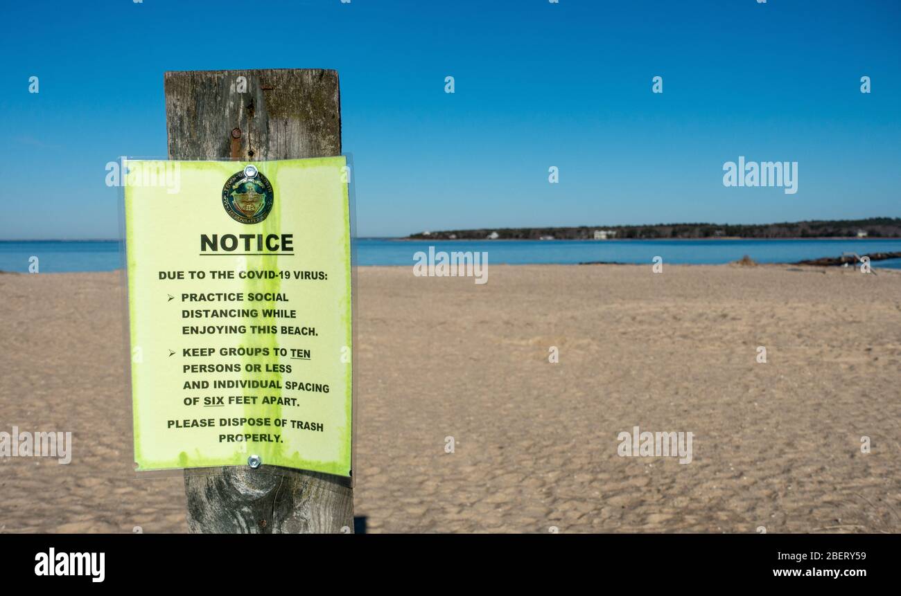 Covid-19 Virus Notice at beach for social distancing of six feet apart and groups ten people or less in Falmouth, Cape Cod, Massachusetts USA Stock Photo
