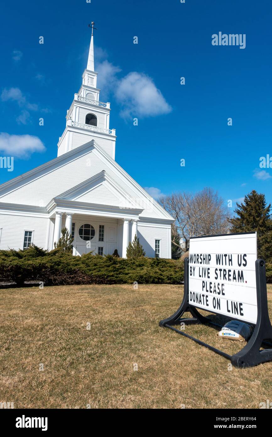 A US Catholic church during the coronavirus pandemic with a sign to Worship with us by Live Stream Please Donate Online Stock Photo