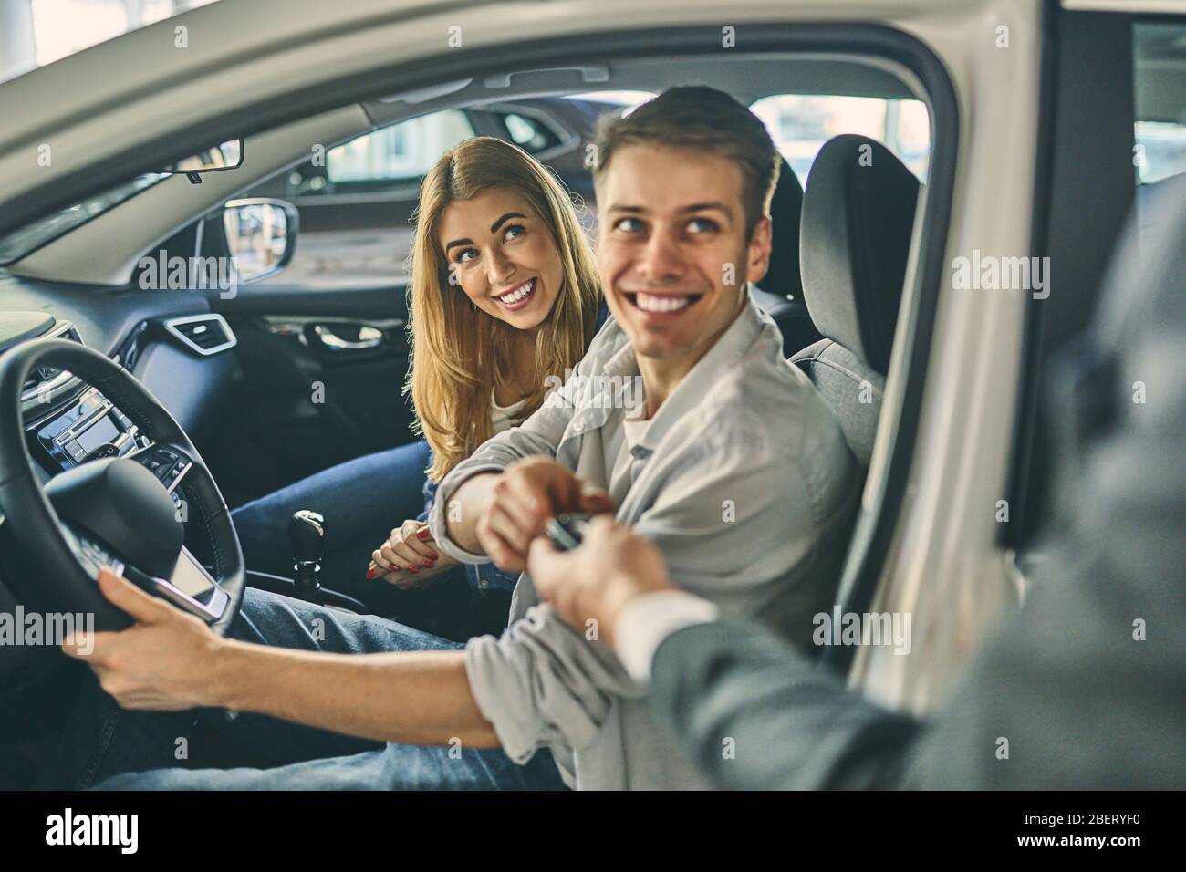 Dealer hand giving a key to new car owners Stock Photo - Alamy