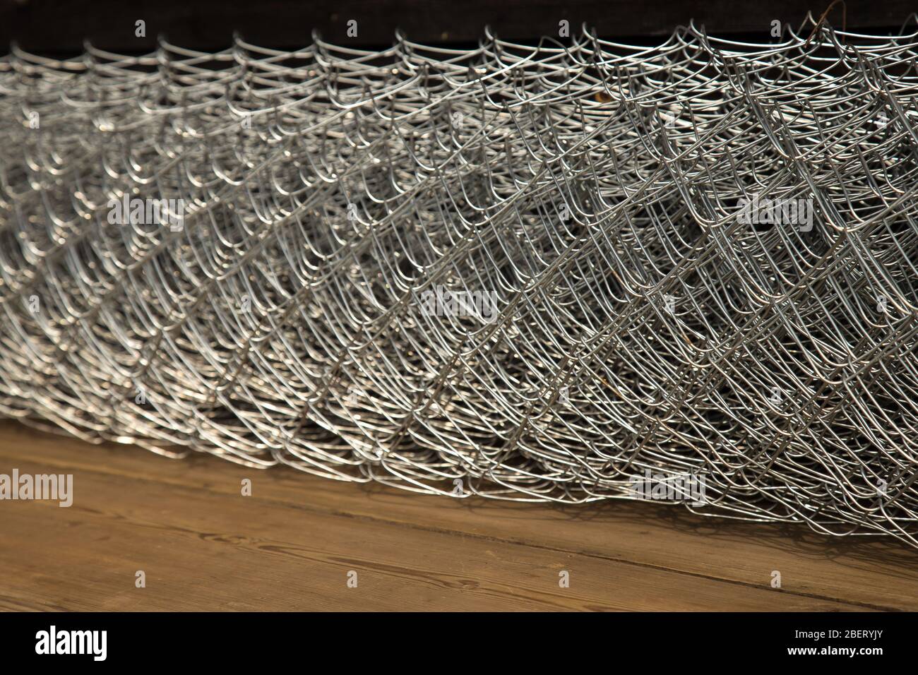 Rabitz grid in a roll on a wooden background. Stock Photo