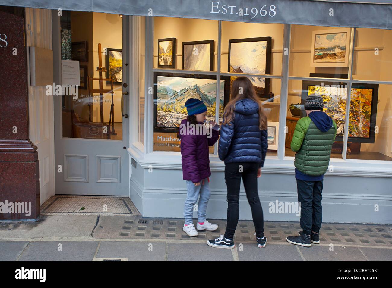 Three children looking at art through Thackeray art shop window Stock Photo