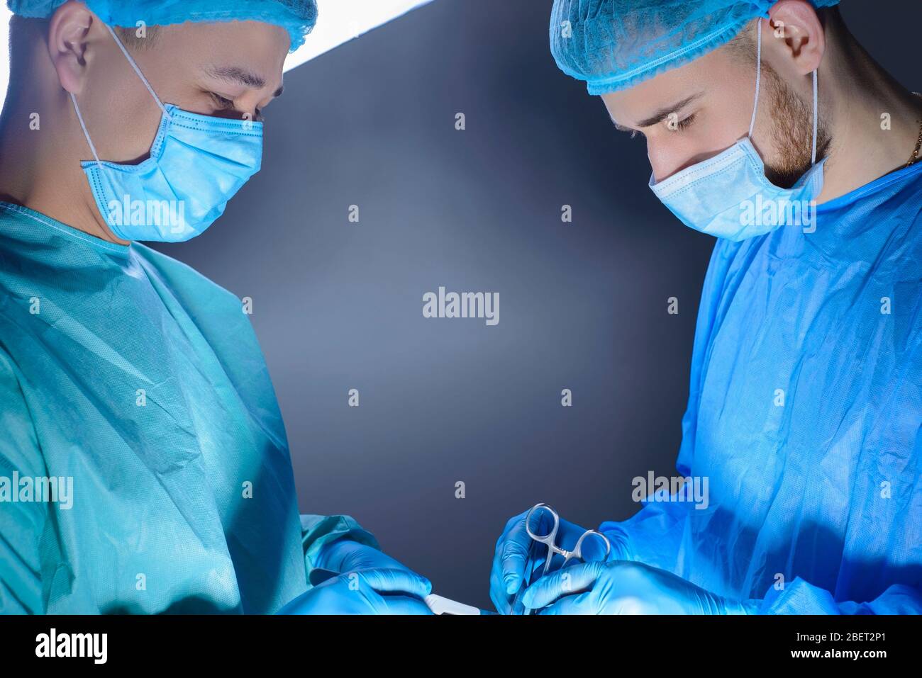 closeup portrait of two surgeons operating in an operating room with