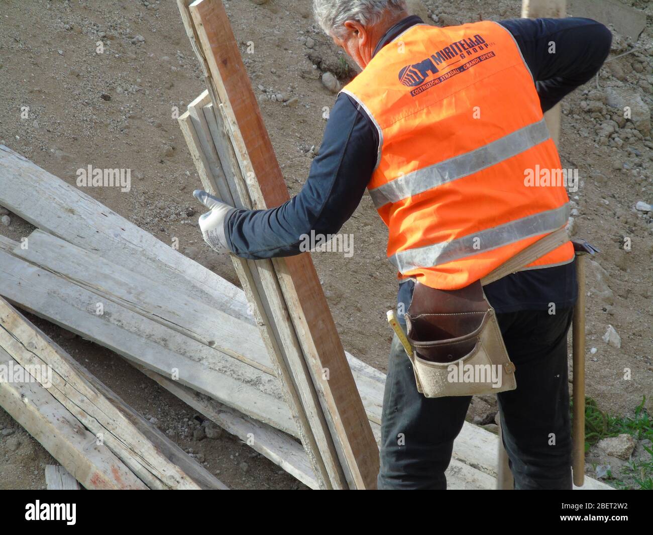 Worker on a construction site handling wooden axis Stock Photo Alamy