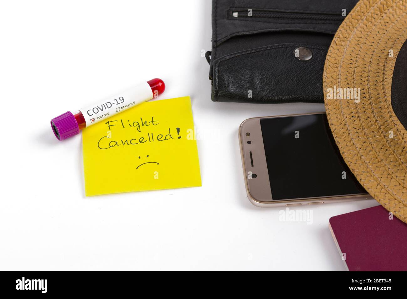 Top view of travel accessory (passport,phone, hat and wallet), note flight canceled and positive coronavirus blood test, isolated on a white backgroun Stock Photo