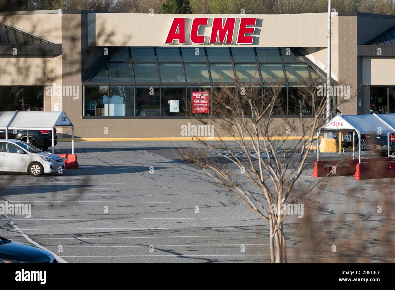 A logo sign outside of a Acme Markets retail grocery store location in
