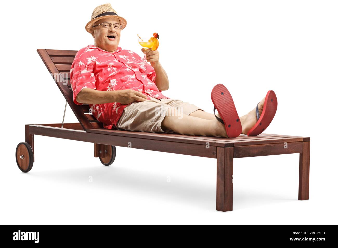 Elderly male tourist lying on a sunbed and drinking a cocktail isolated on  white background Stock Photo - Alamy