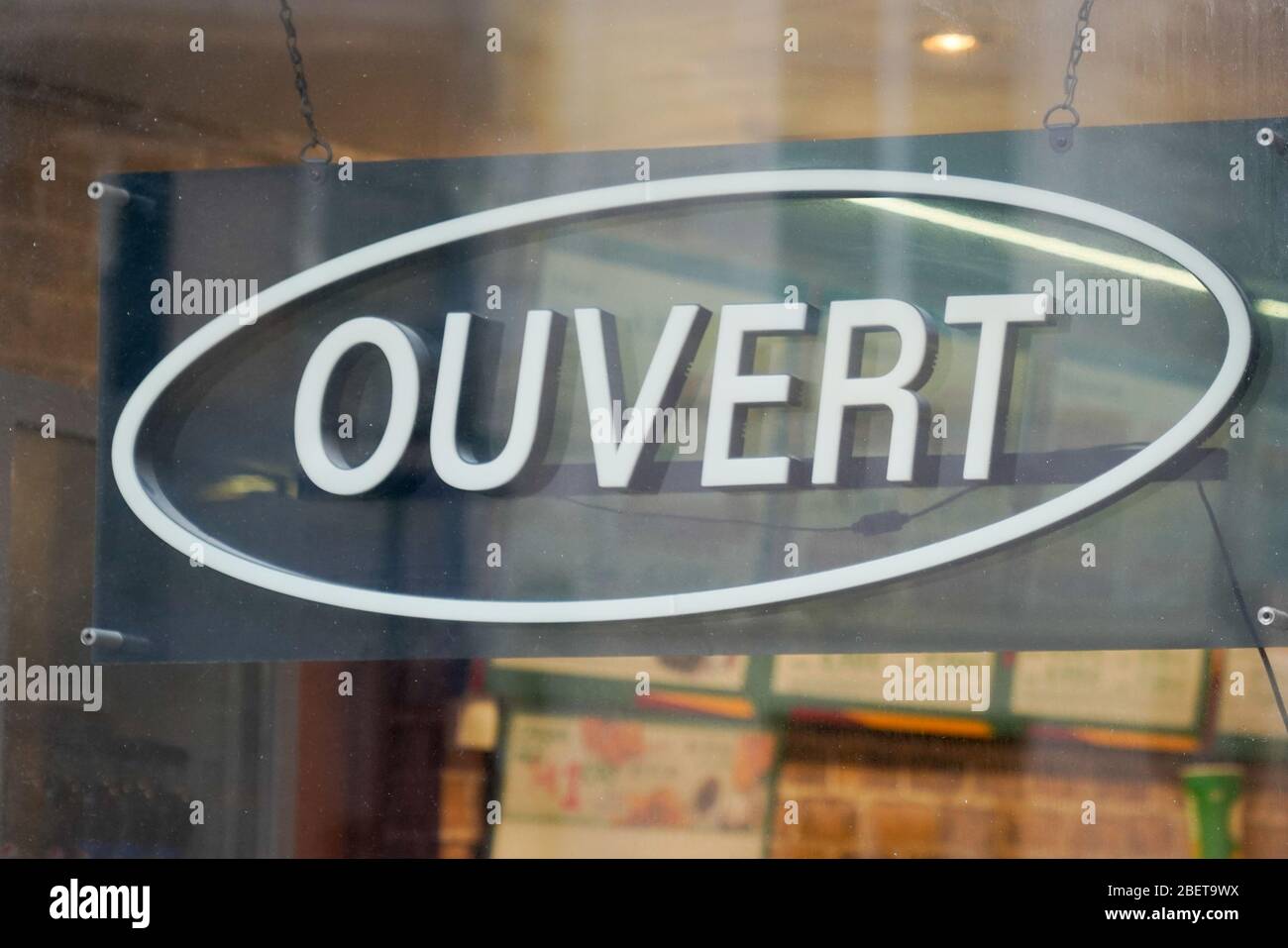 open sign in french means ouvert hanging on the entrance door of a small business concept in france Stock Photo