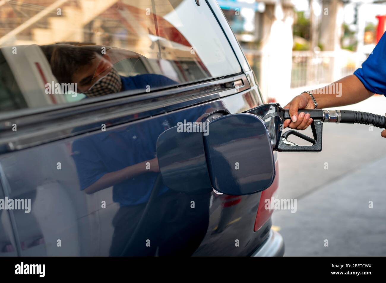 Male hand fill up petrol tank gasoline fuel petrol in car being filled