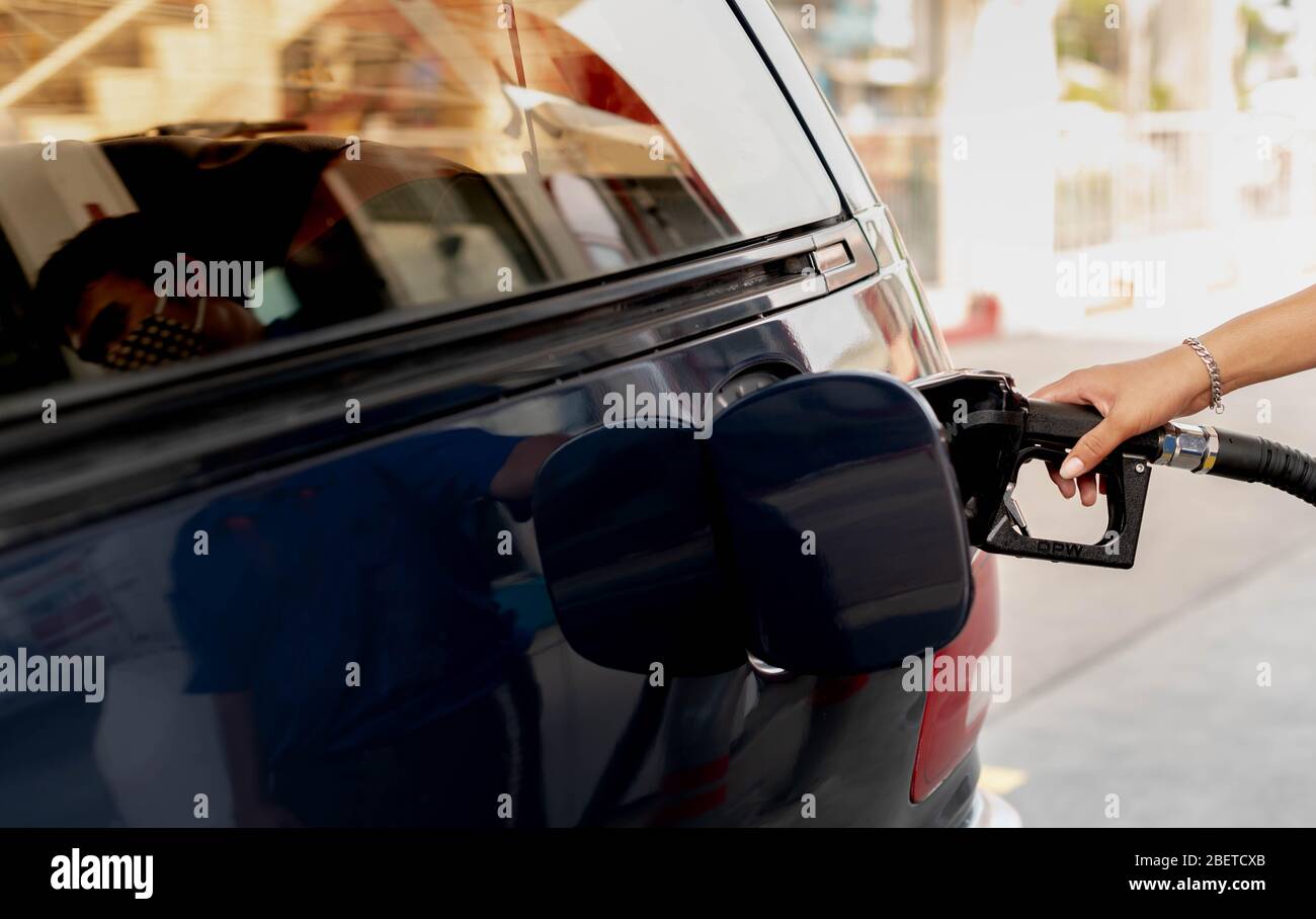 Male hand fill up petrol tank gasoline fuel petrol in car being filled