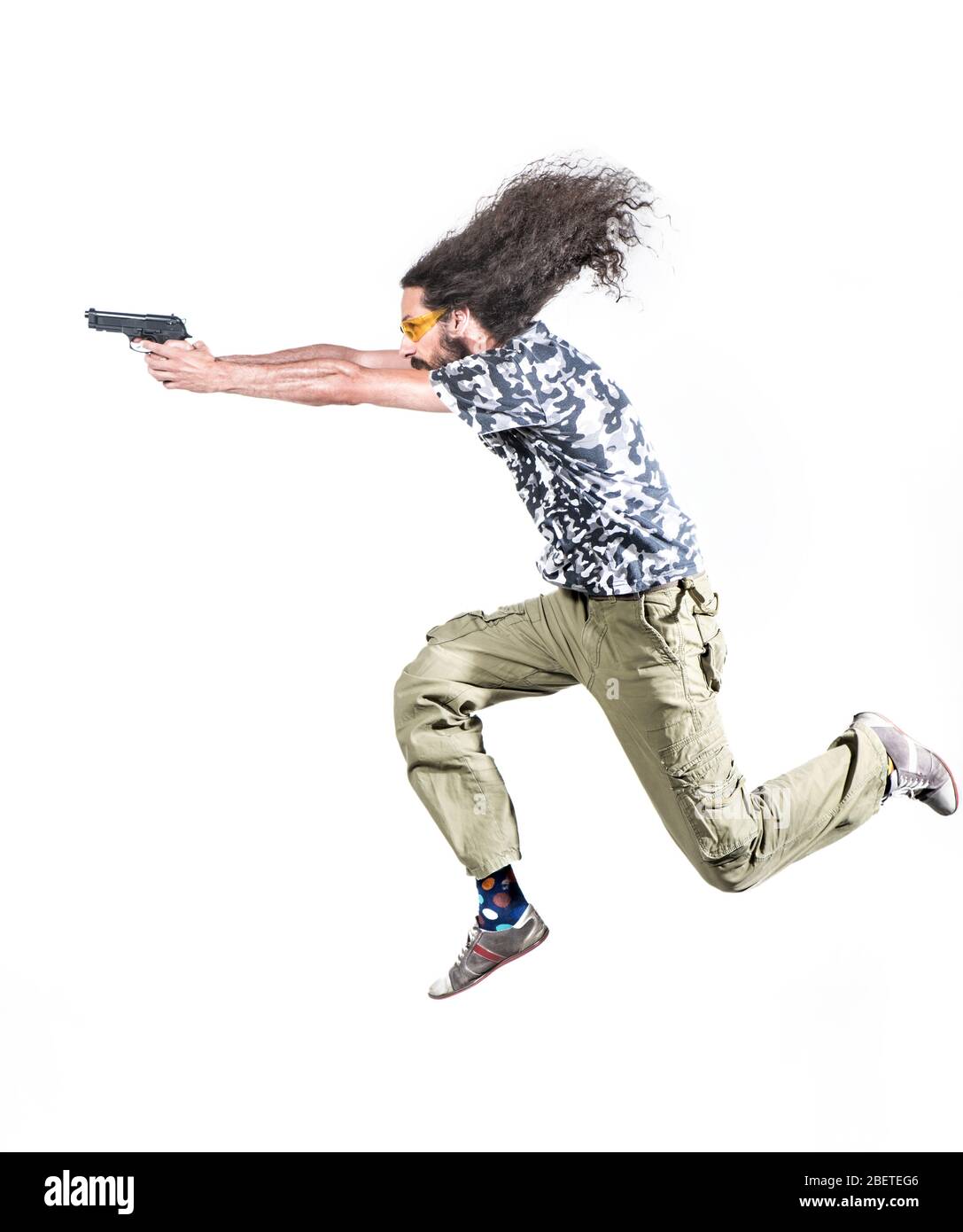 Portrait of a skinny guy poiting a gun - isolated Stock Photo