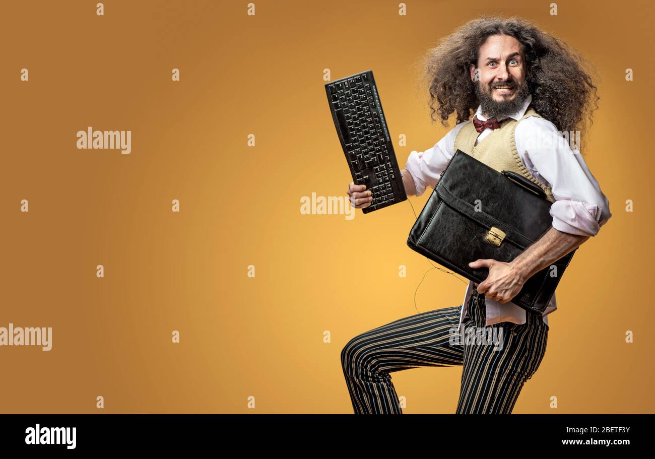Portrait of a skinny nerd holding the keyboard and a briefcase Stock Photo