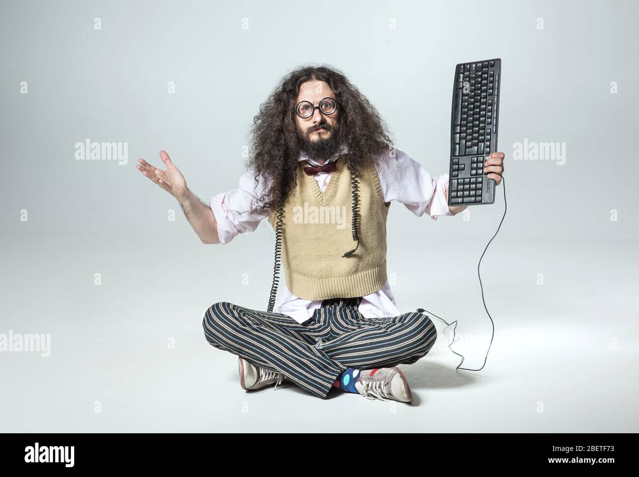 Calm geek holding a pc keyboard Stock Photo
