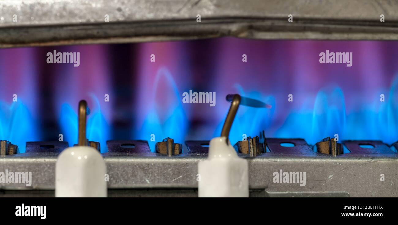 Gas burns in modern water heater. Closeup. Selective focus. Stock Photo
