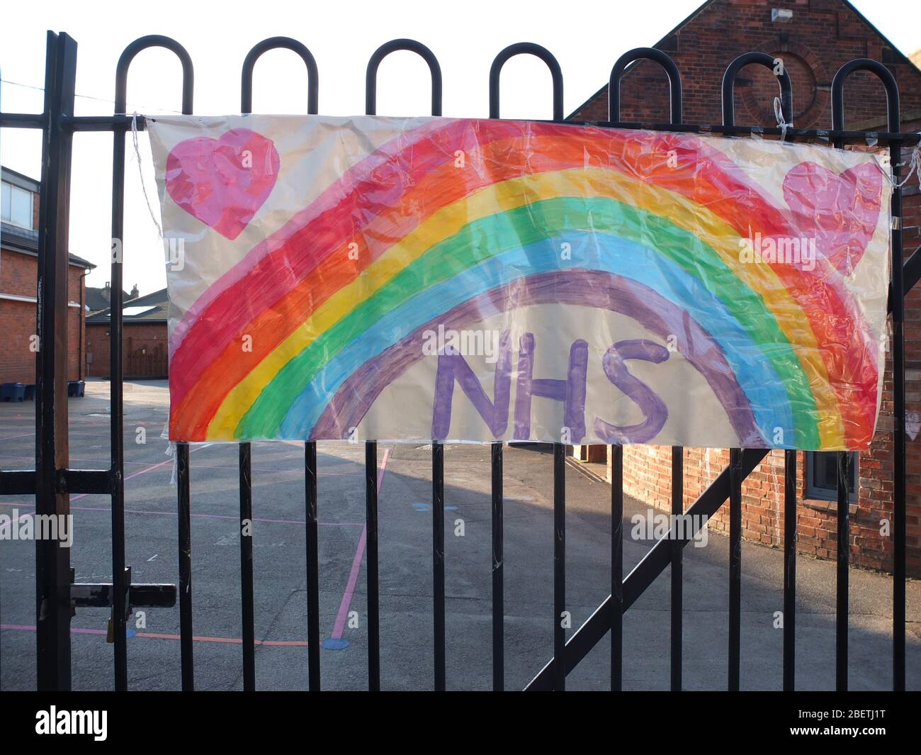 Children's pictures of rainbows stuck to the railings of a closed primary school in Sheffield UK during the Coronavirus crisis (Scared Heart School) Stock Photo