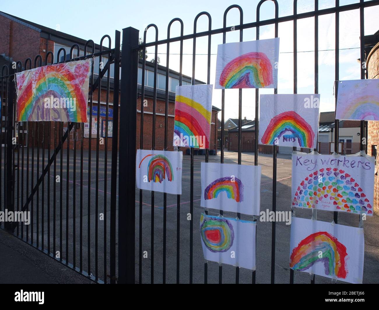 Children's pictures of rainbows stuck to the railings of a closed primary school in Sheffield UK during the Coronavirus crisis (Scared Heart School) Stock Photo