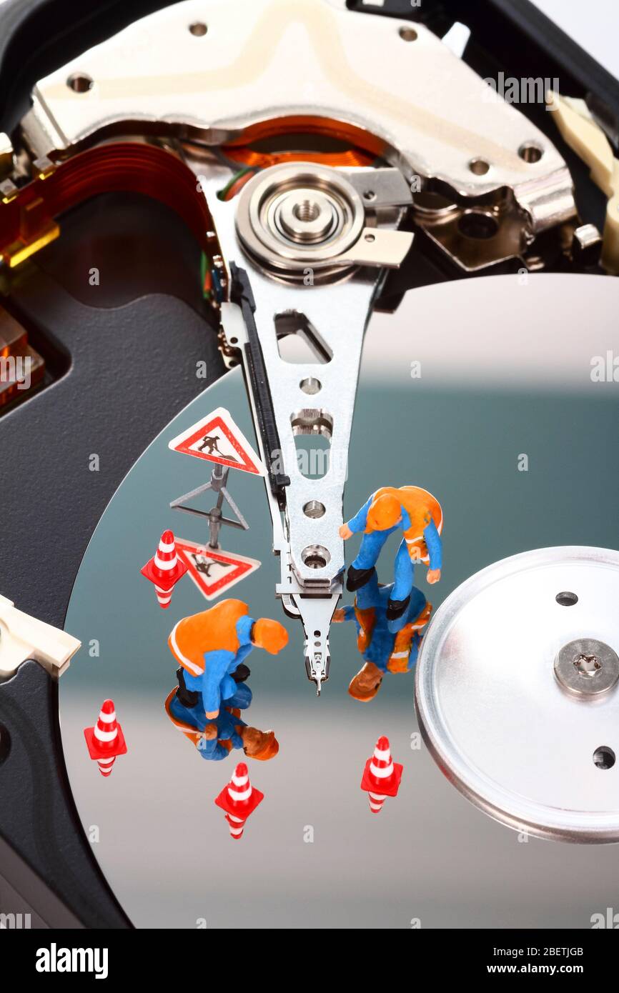 Conceptual image of miniature figure people looking for problems on a computer hard drive Stock Photo
