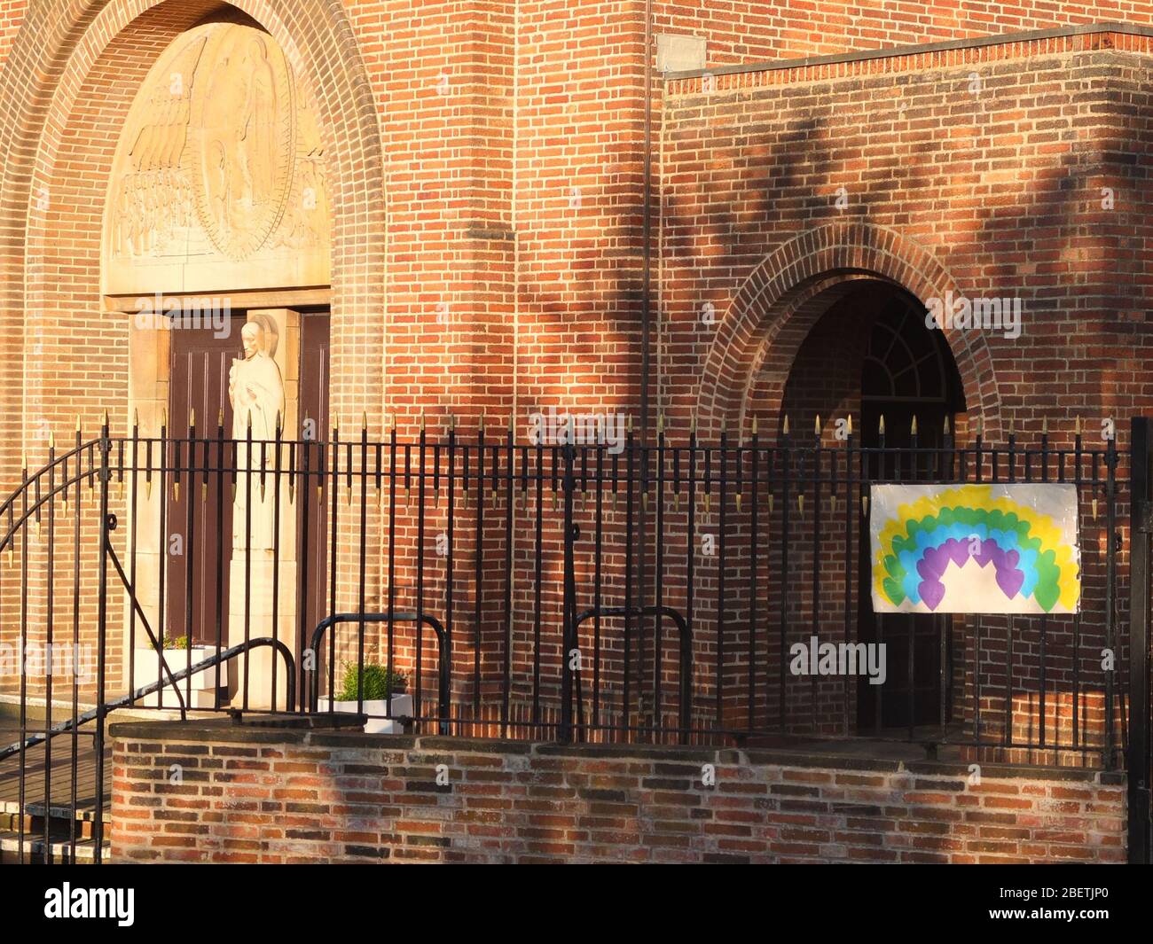 A sign of hope of a rainbow made of hearts on the railings of Scared Heart Catholic Church, Hillsborough, Sheffield, UK, closed due to Coronavirus Stock Photo