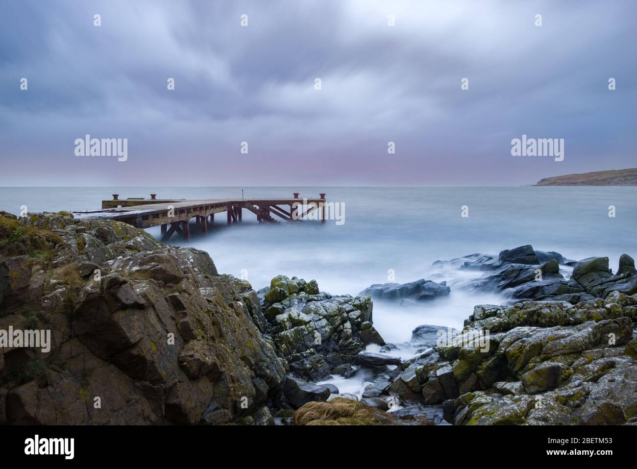 Looking over the rocky harbour  to the old jetty at Portencross in Seamill West Kilbride on a stormy March. Stock Photo