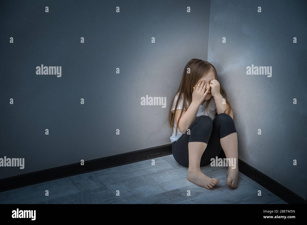 Unhappy Child Sitting In Corner Of Room Stock Photo Alamy