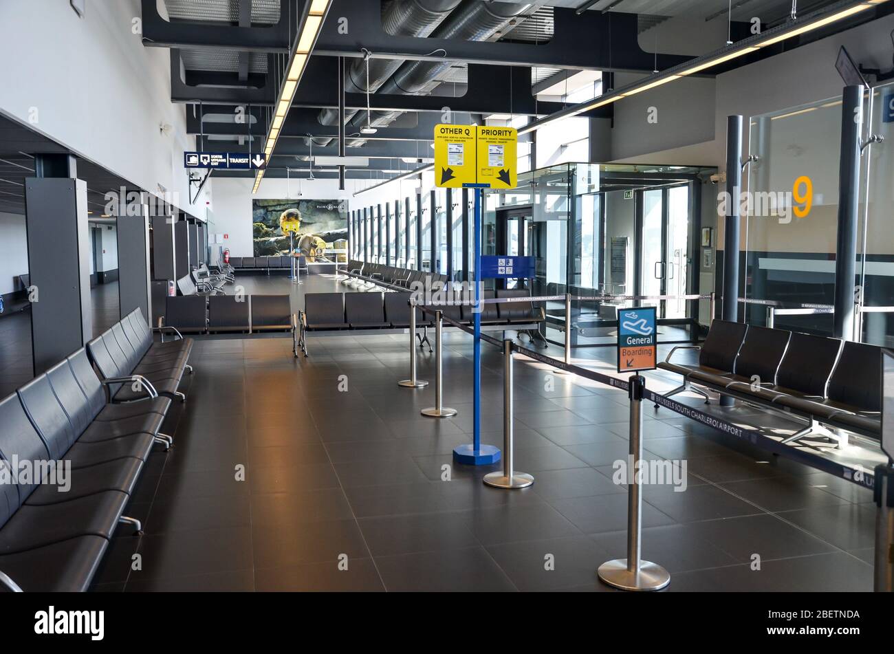 Charleroi, Brussels, Belgium - March 17, 2020: Empty airport terminal in the Belgian airport. Gate with no people. Travel restriction due to coronavirus pandemic. COVID-19 shutdown. Cancelled flights. Stock Photo